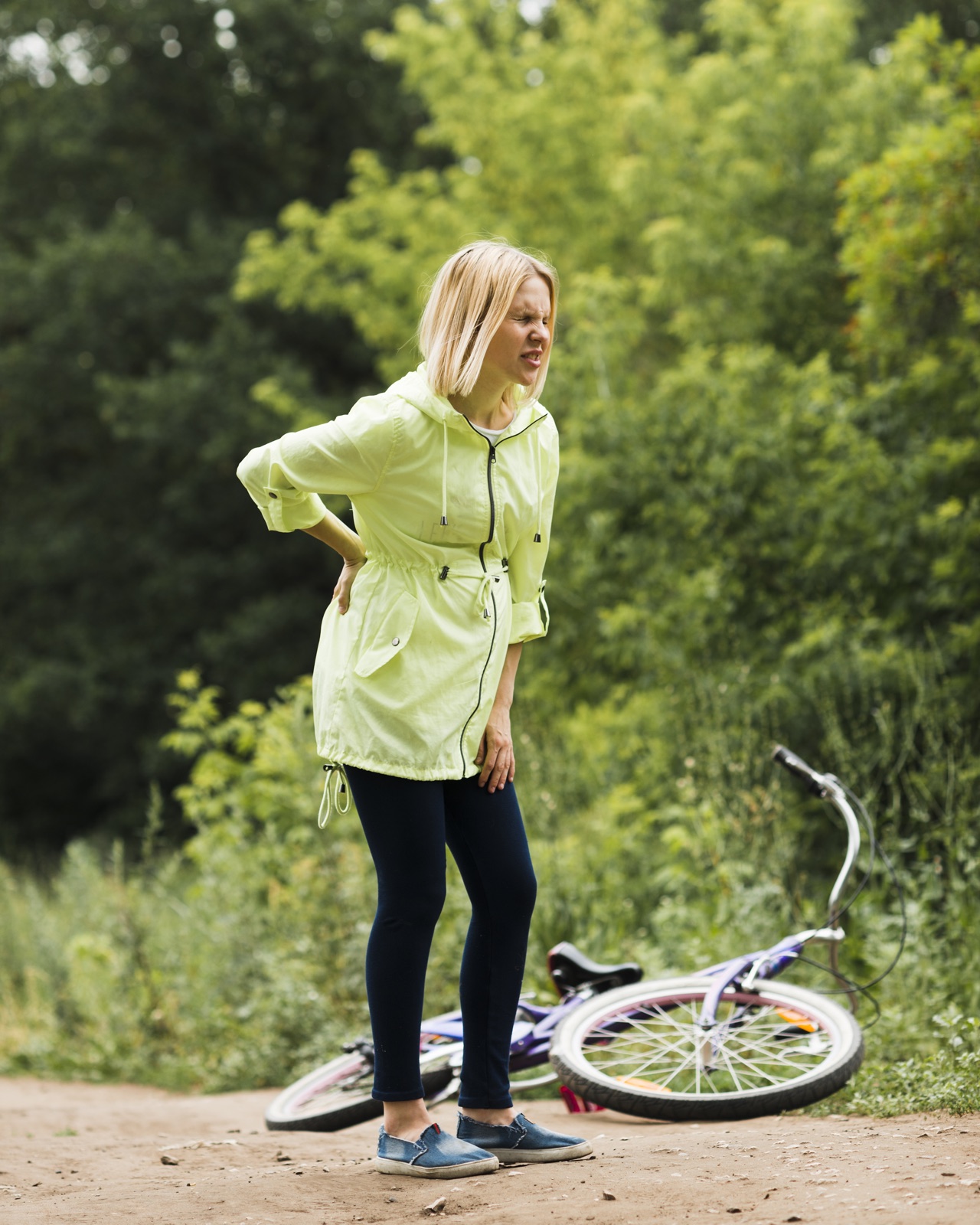 A person with back pain beside a bicycle